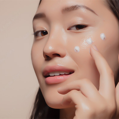 modella coreana applica crema sul viso